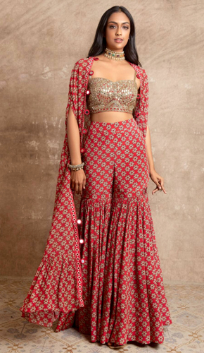 Elegant red georgette floral print cape and sharara set with mirror embroidered border. perfect diwali outfit with open neckline and short sleeves.