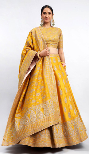 Mustard yellow raw silk lehenga with kashmiri tilla embroidered paisley motifs, paired with a blouse and dupatta. Mustard yellow raw silk lehenga with kashmiri tilla embroidered paisley motifs, paired with a blouse and dupatta.
